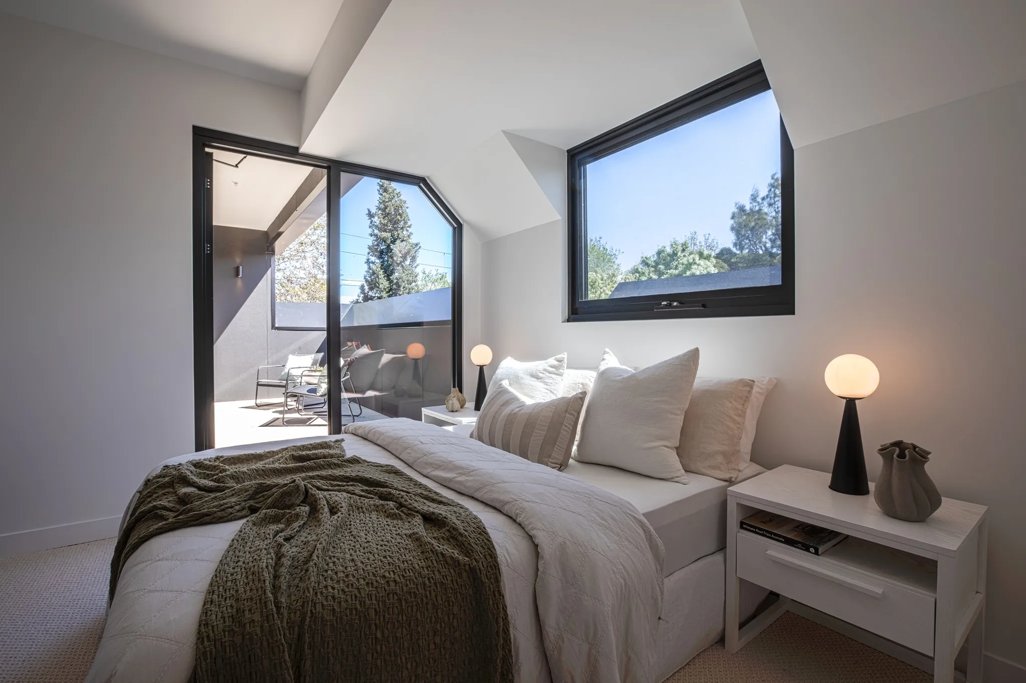 Sunlit bedroom with angled windows and balcony access, Mode De Vie apartments by Pascon.
