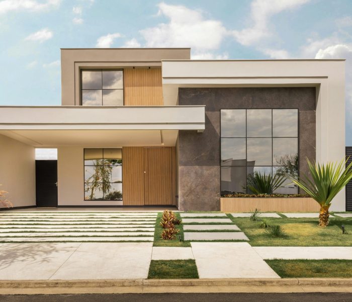 Contemporary house exterior with minimalist design, large windows, and landscaped front yard.